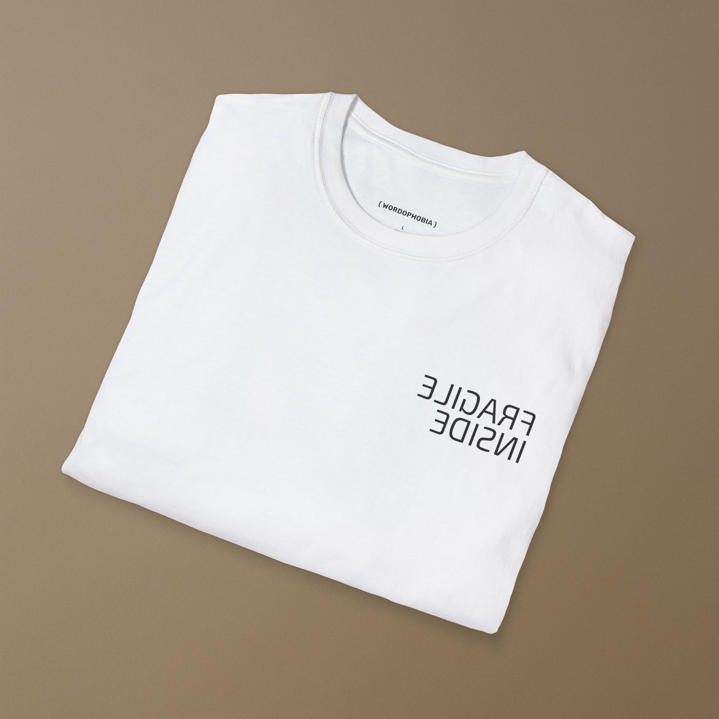 Minimalist folded t-shirt with phrase “Fragile Inside” in white cotton