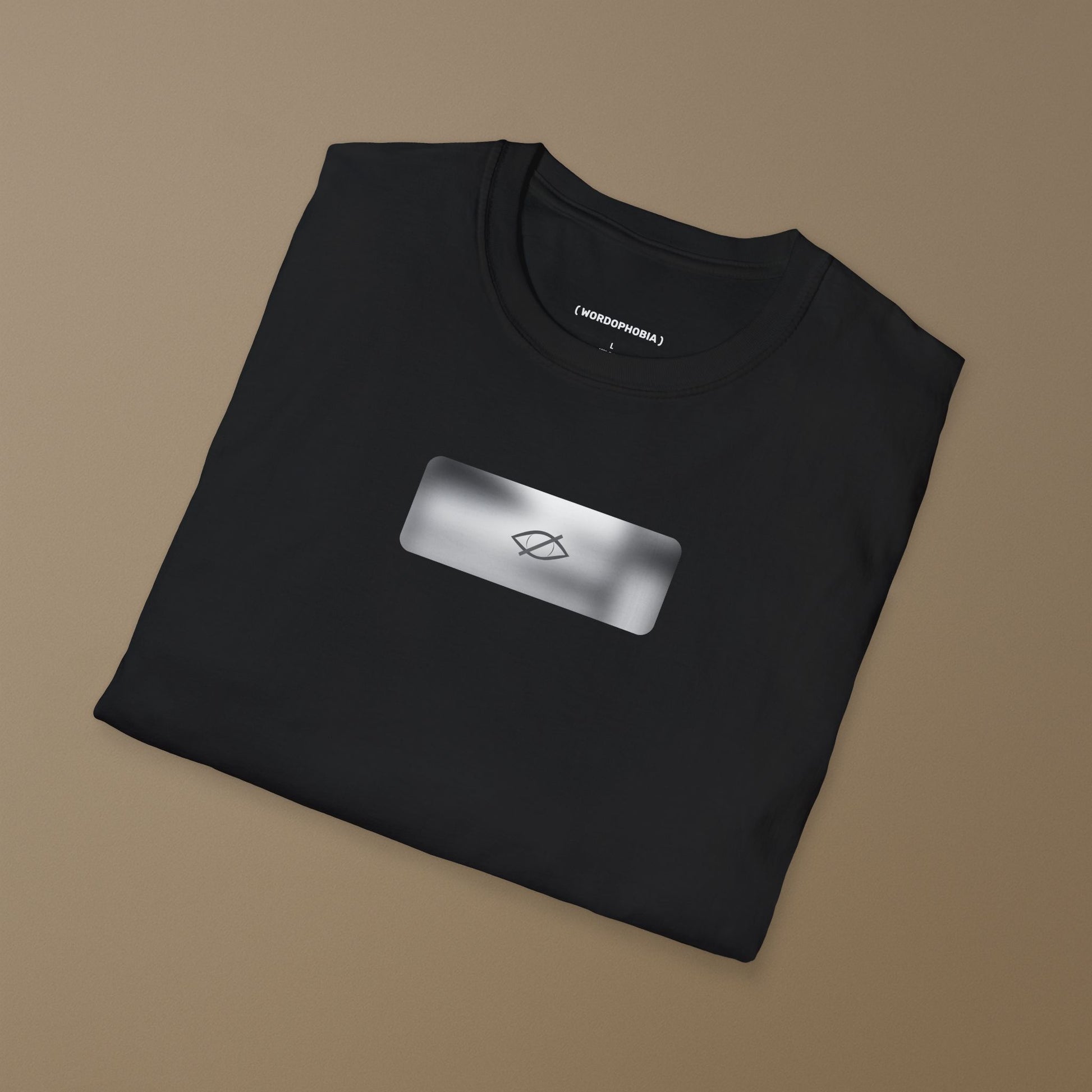 Folded black t-shirt with a a small blurred symbol "Sensitive content" on a beige background