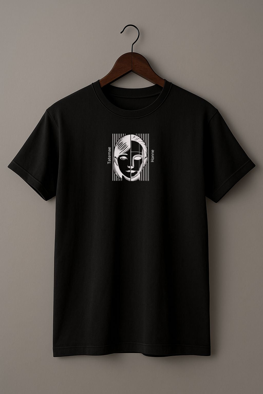 Black t-shirt with a graphic design of a face with 'Tatemae' and 'Honne' text on a hanger against a beige background