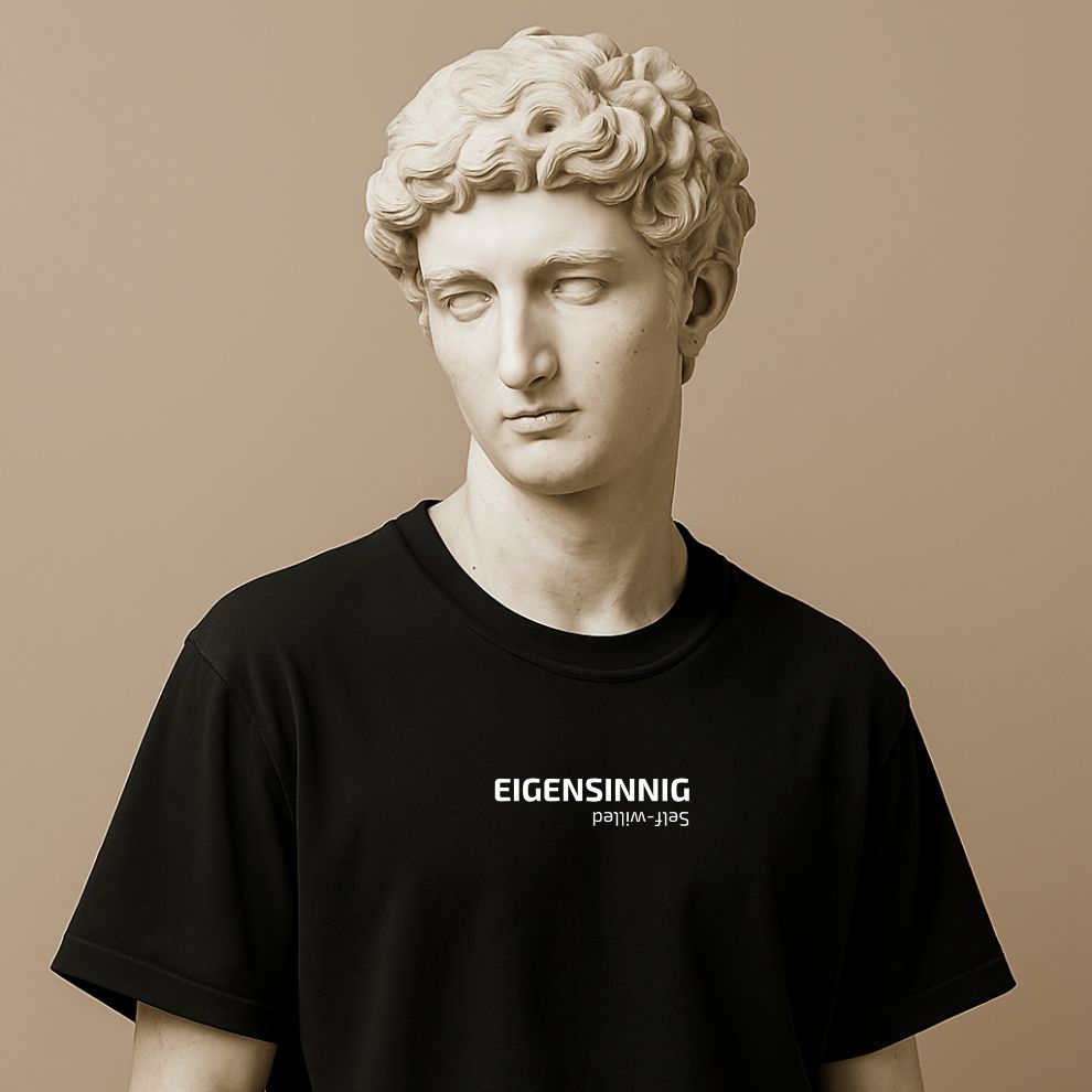 Minimalist unisex t-shirt with “Eigensinnig” printed in bold font on the statue. Cotton fabric, black or white. Word for independent thinking.