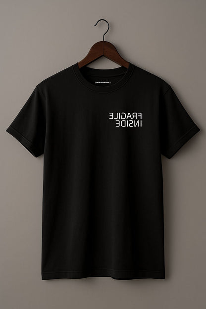 Mockup of minimalist folded t-shirt with phrase “Fragile Inside” in black cotton