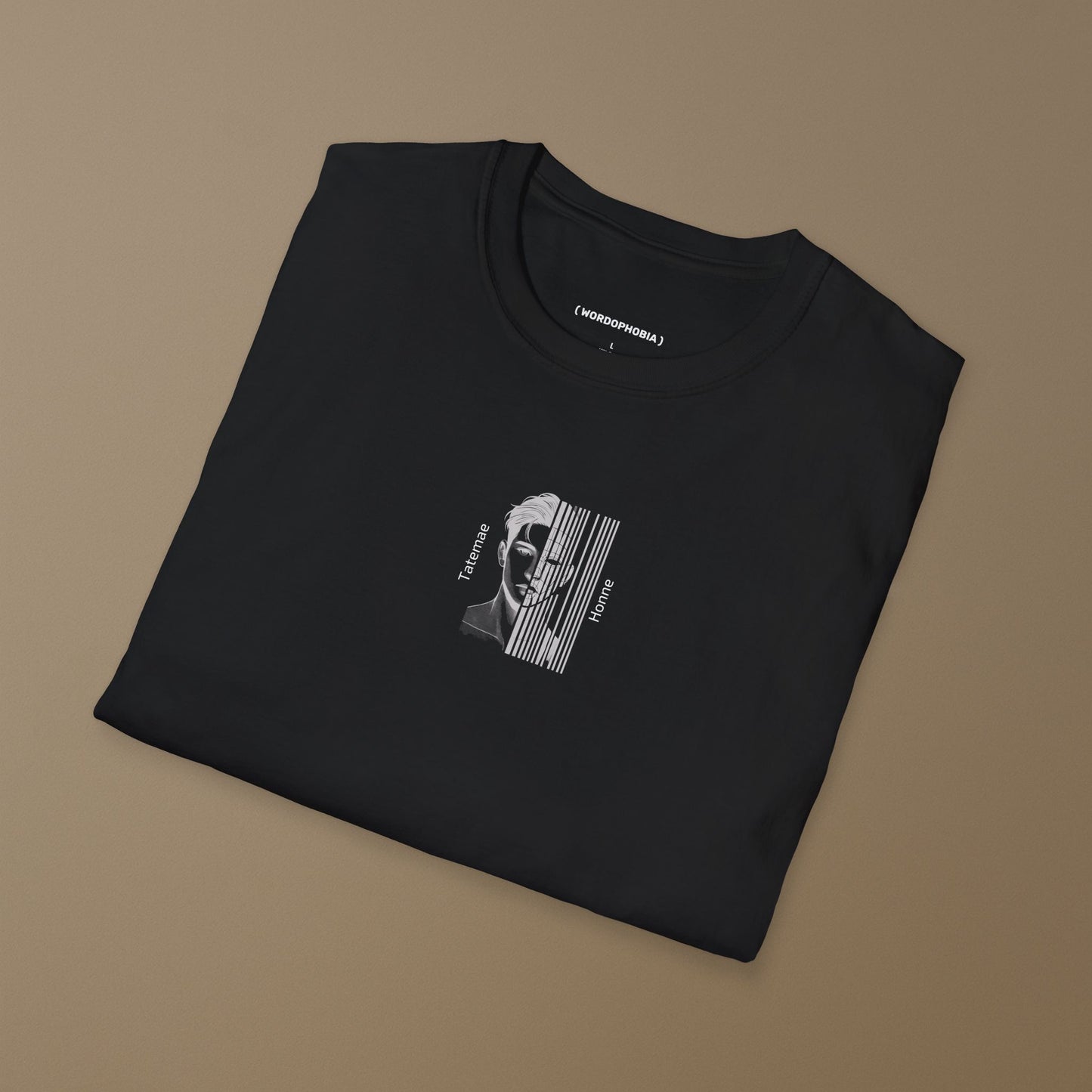 Folded black t-shirt with a graphic design of a Black and white illustration of a man with 'Tatemae' and 'Honne' text  on a brown background