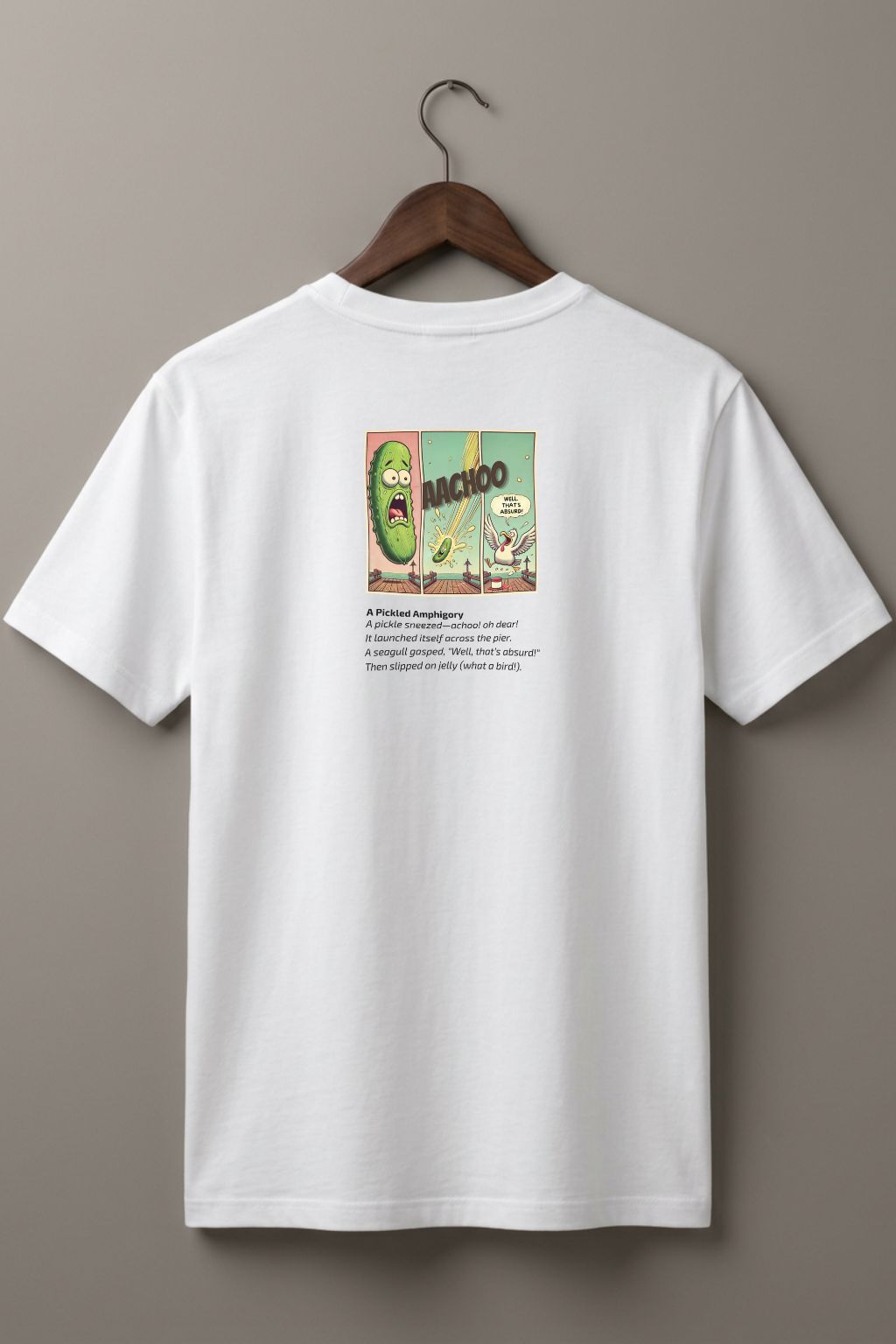 White t-shirt (back side)  with a graphic comic design of a pickle and a poem below on a hanger against a plain wall