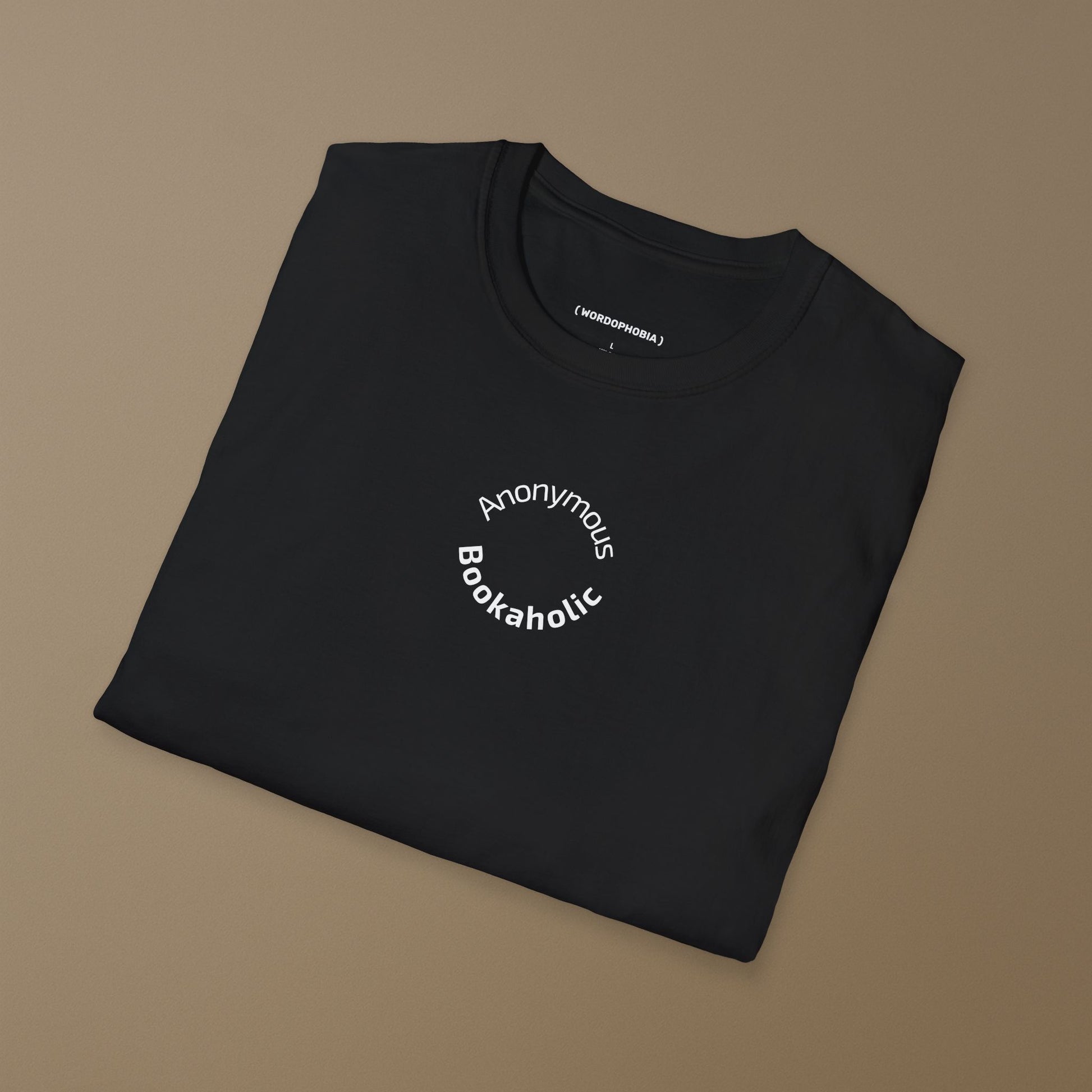 Folded black t-shirt with 'Anonymous Bookaholic' text on a brown background