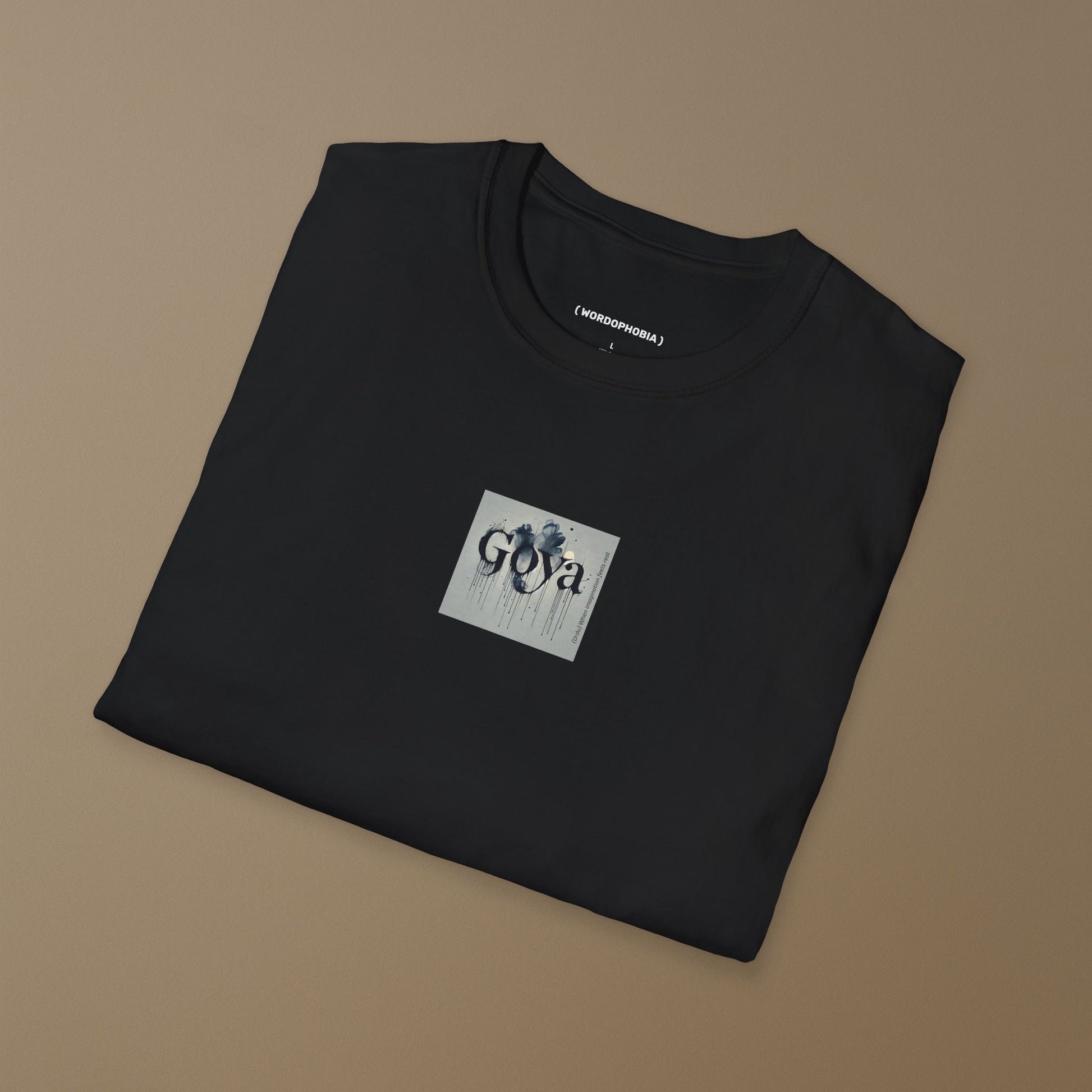 Folded black t-shirt with 'Goya' design on a brown background
