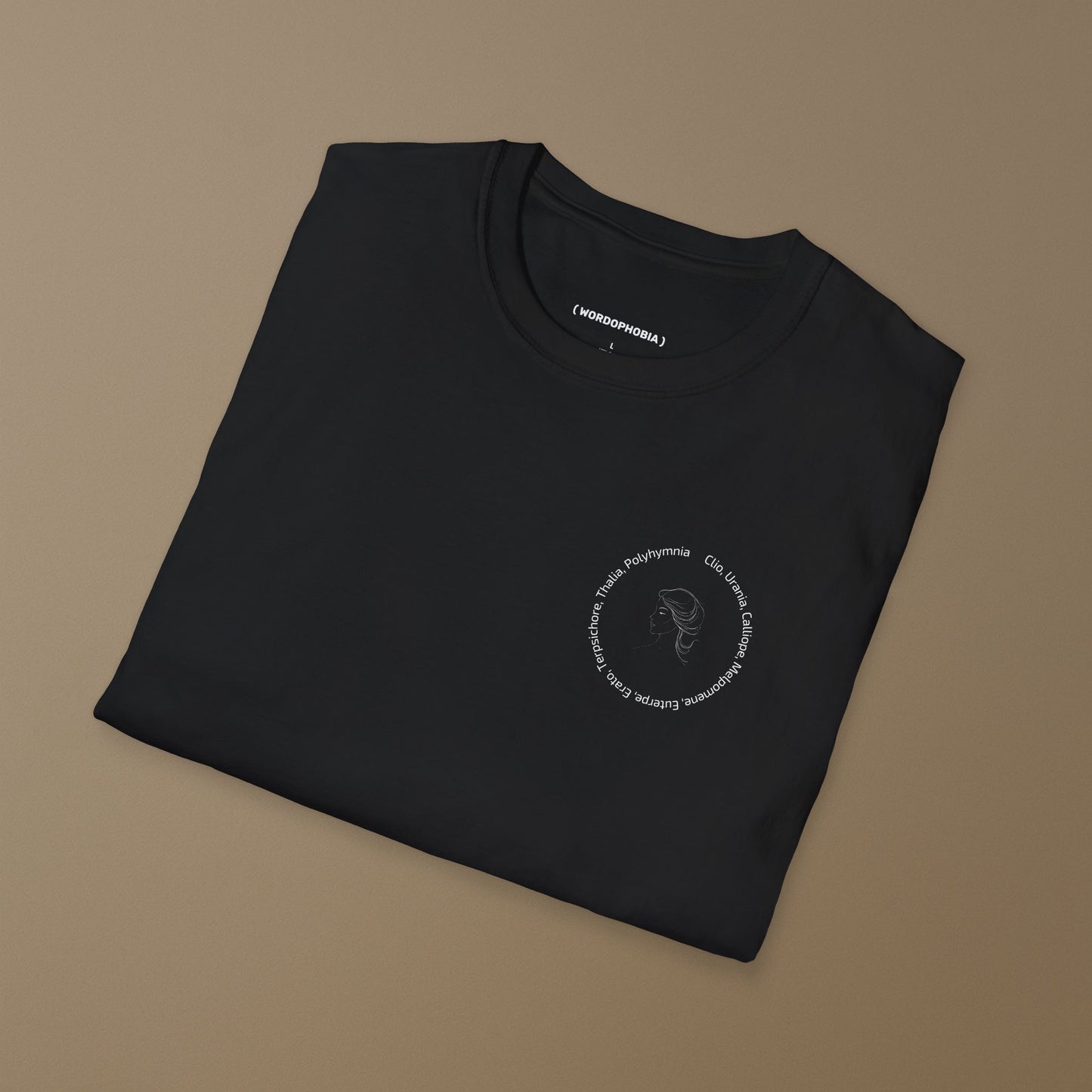 Folded black t-shirt with a graphic of a line drawing of a classical woman's profile with Greek goddess names around her head on a beige background