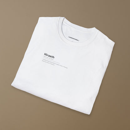 Folded white t-shirt with graphic design of the word HIRAETH ([ˈHeer-eye-th], Welsh) and its definition "A bittersweet yearning for a place, time, or feeling that lives only in memory" on a plain background