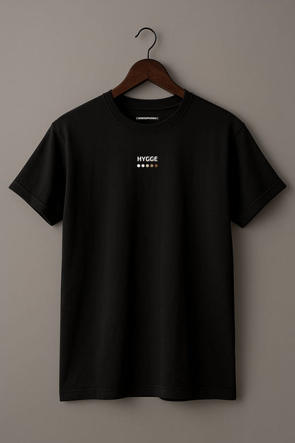 Black t-shirt with 'Hygge' text on a wooden hanger against a plain background