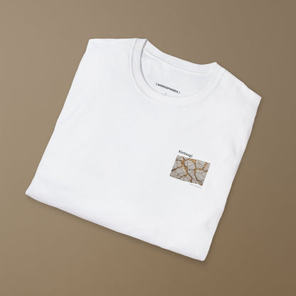 Folded white t-shirt with a small graphic of Kintsugi art with gold repair on a cracked white surface, text 'Kintsugi The art of healing' above on a brown background