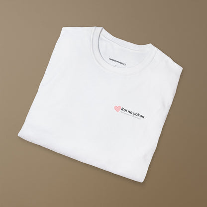 Folded white t-shirt with with typographic design of the phrase “Koi no yokan,” a Japanese expression describing the feeling that love is destined to happen, and small heart on a beige background