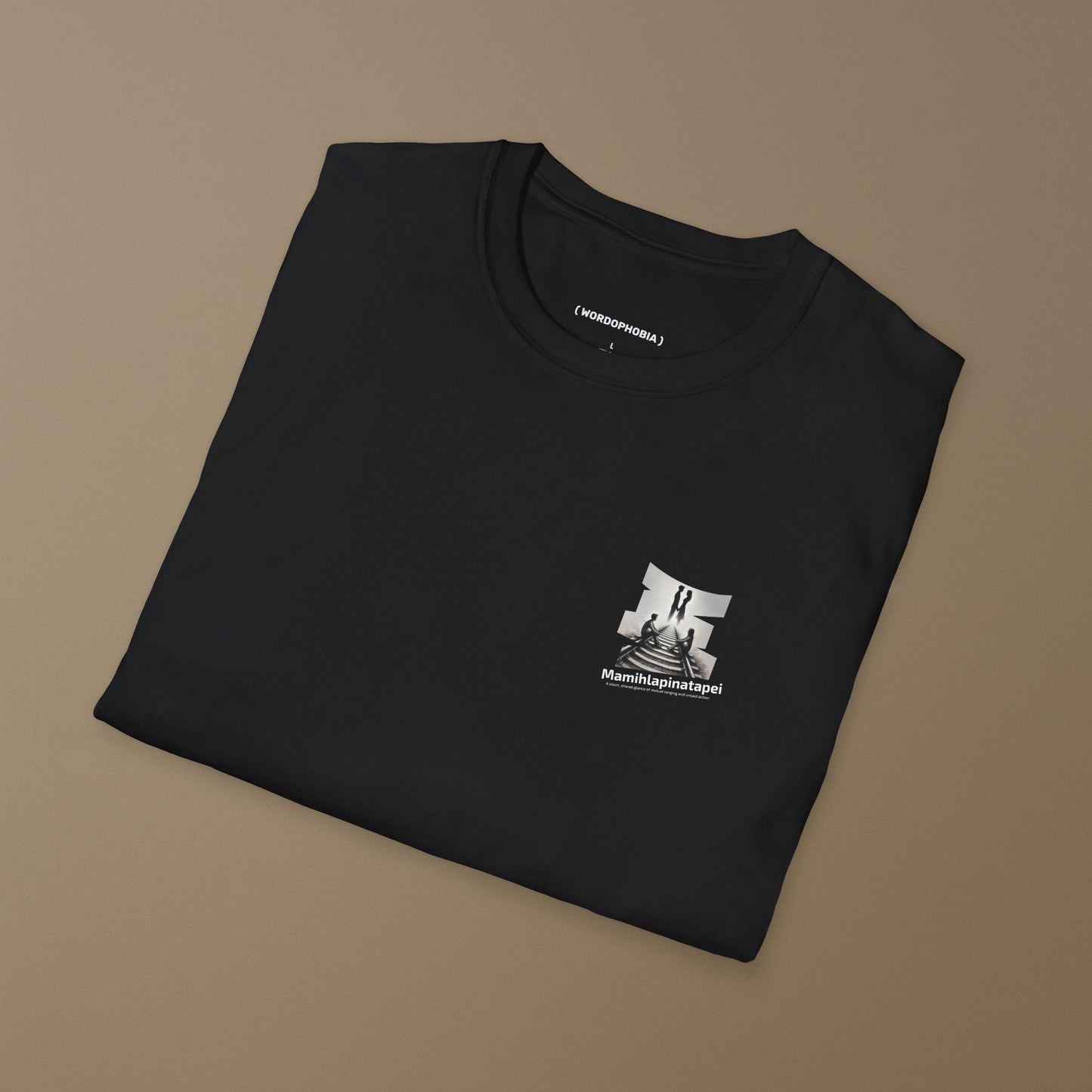 Folded black t-shirt with a graphic of a silhouette artwork of two people on a railway track with text 'Mamihlapinatapei' 