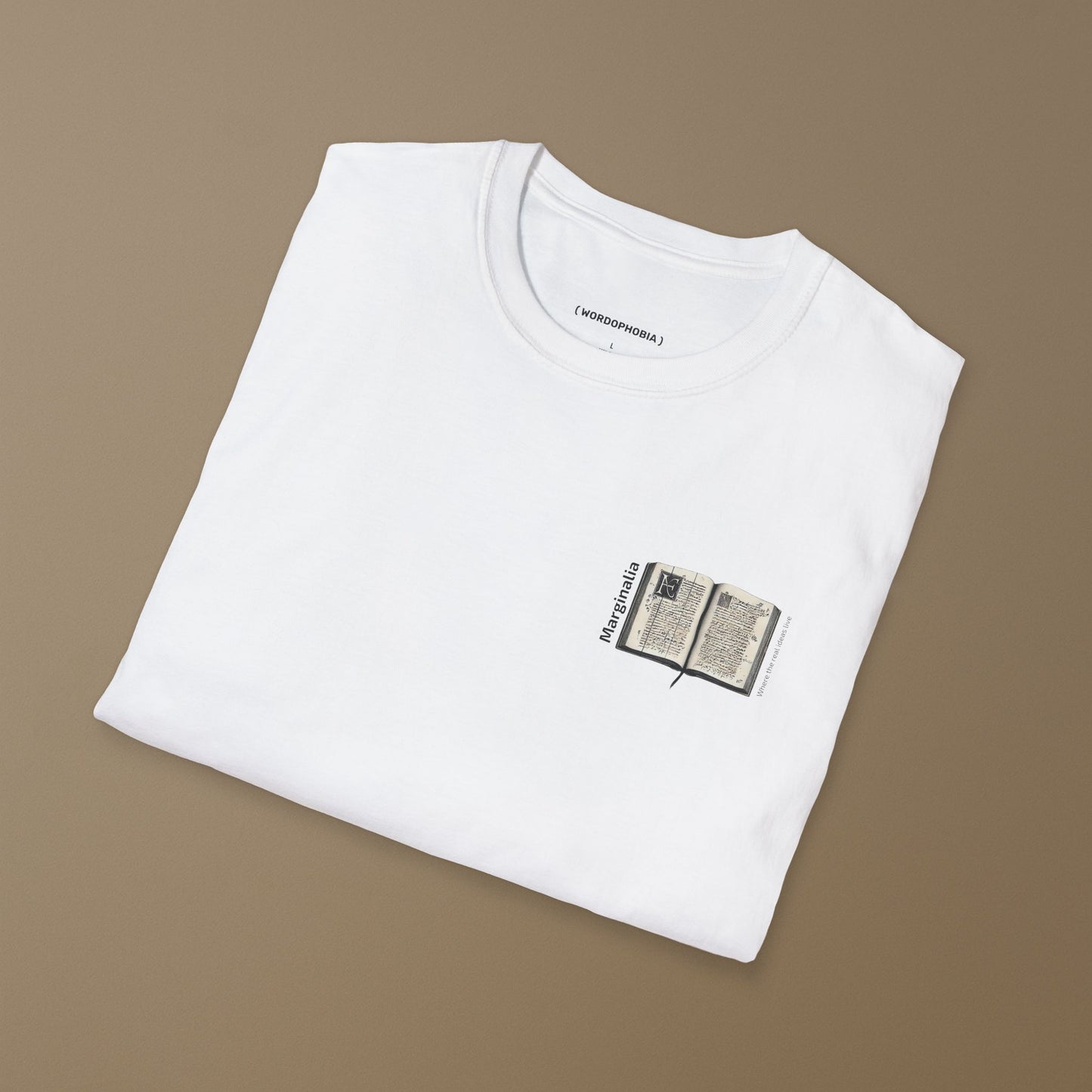 Folded white t-shirt with a small graphic of White t-shirt with a small graphic of open old book with text "Marginalia" and "Where the real ideas live" on a beige background