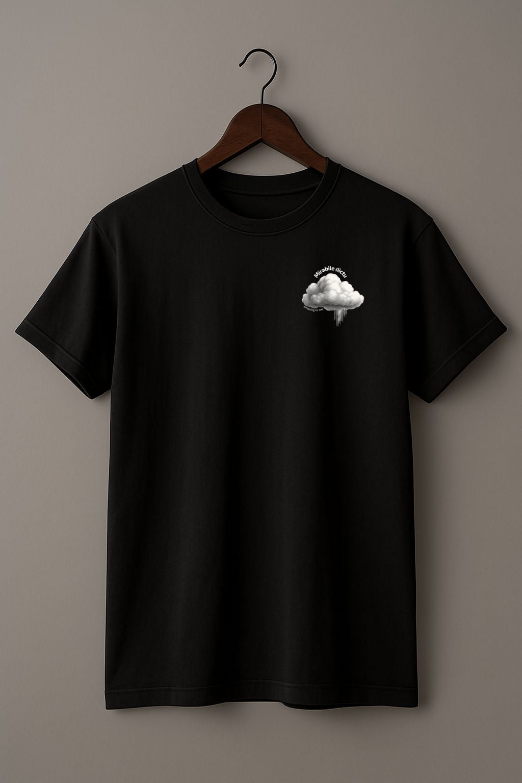 Black t-shirt with a white cloud design and 'Mirabile dictu' and 'Amazing to say' text on a wooden hanger against a beige wall