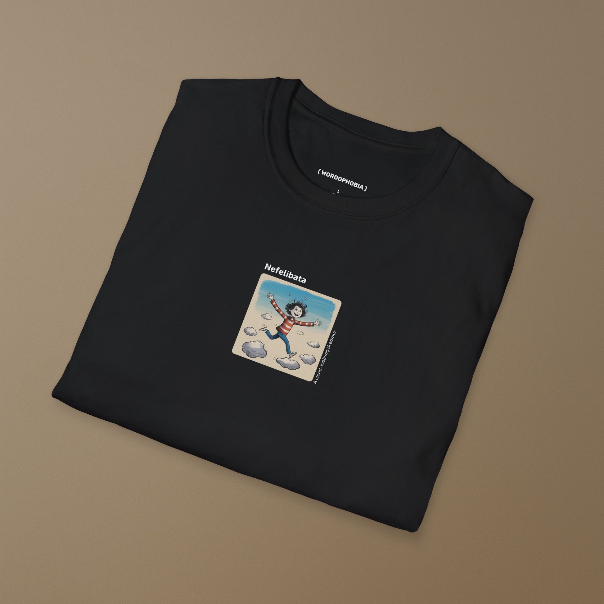 Folded black t-shirt with a graphic design of a  funny child running on clouds with 'Nefelibata' text and phrase "A cloud-walking dreamer" on a beige background