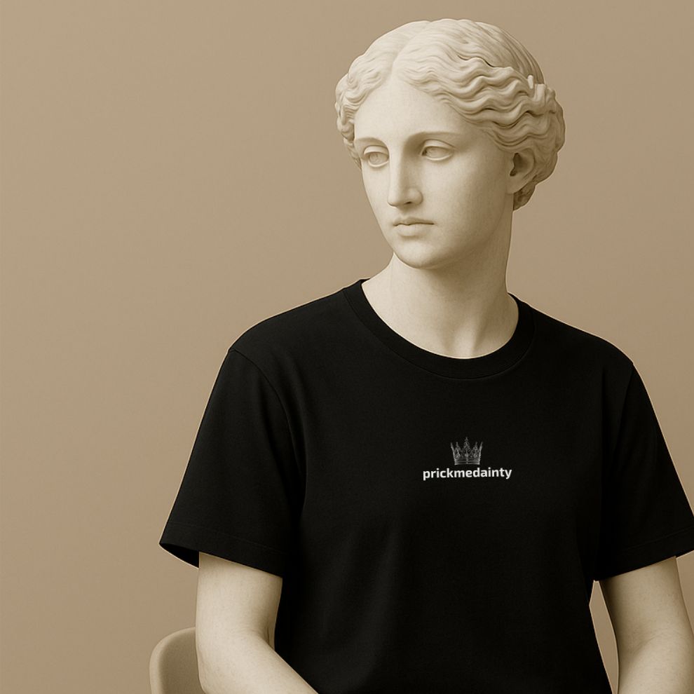 Statue wearing a black t-shirt with a crown and  'prickmedainty' text on a beige background