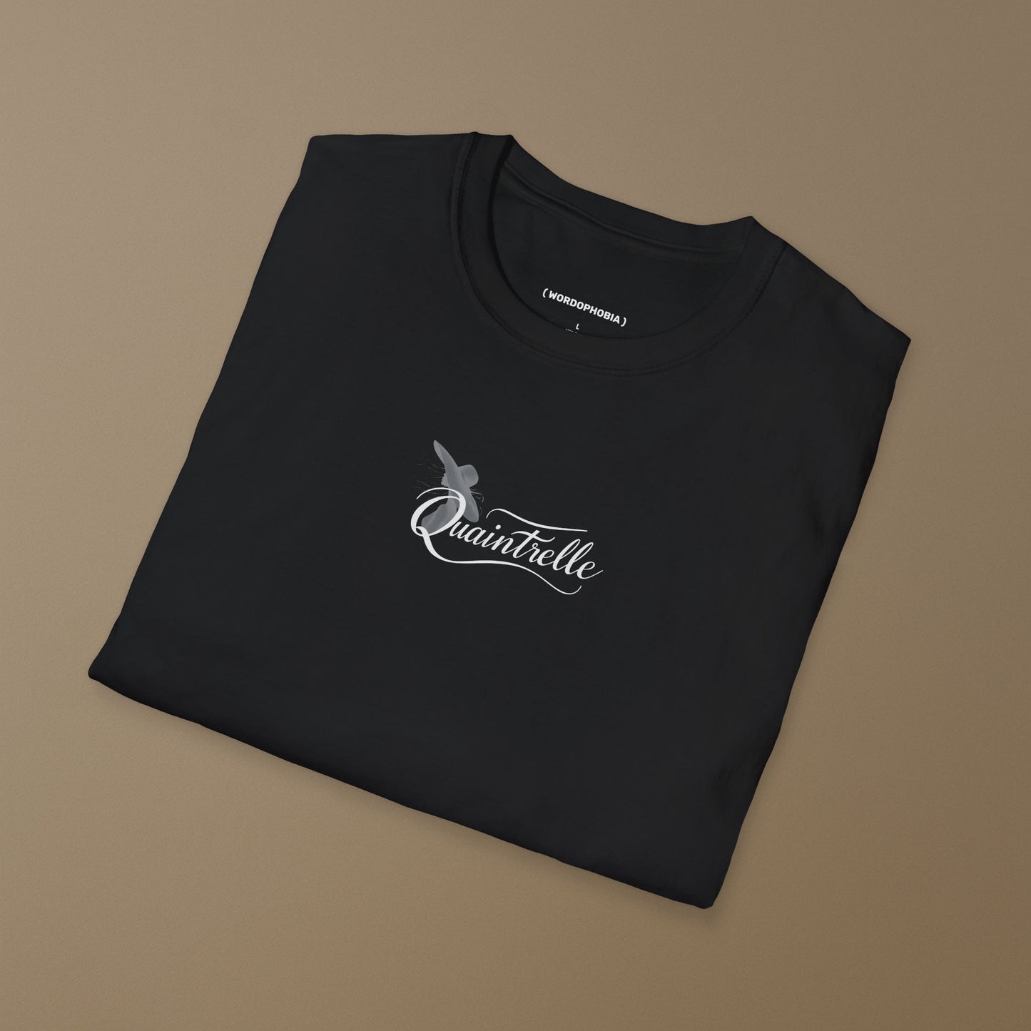 Folded black t-shirt with a small design of a word Quaintrelle, symbolizing elegant and intentional living, and silhouette of women on a beige background