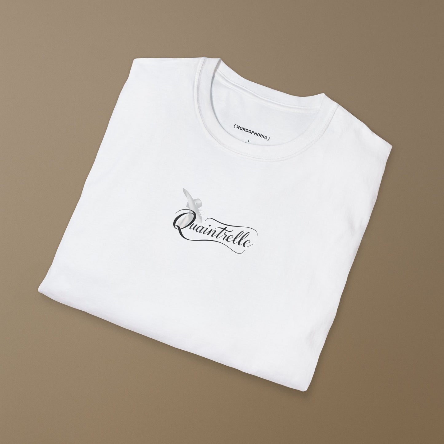 Folded white t-shirt with a small design of a word Quaintrelle, symbolizing elegant and intentional living, and silhouette of women on a beige background