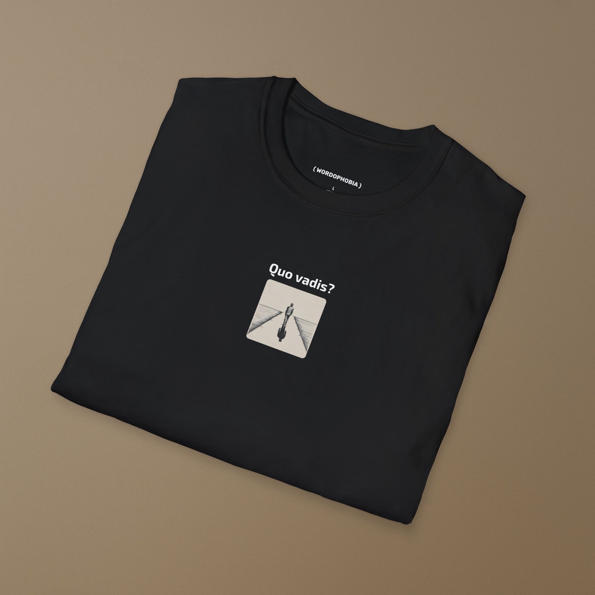 Folded black t-shirt with a black and white illustration of a person standing on a path with 'Quo vadis?' text above on a brown background