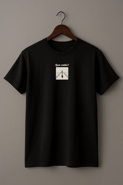Black t-shirt with an illustration of a person standing on a path with 'Quo vadis?' text above on a hanger against a beige background