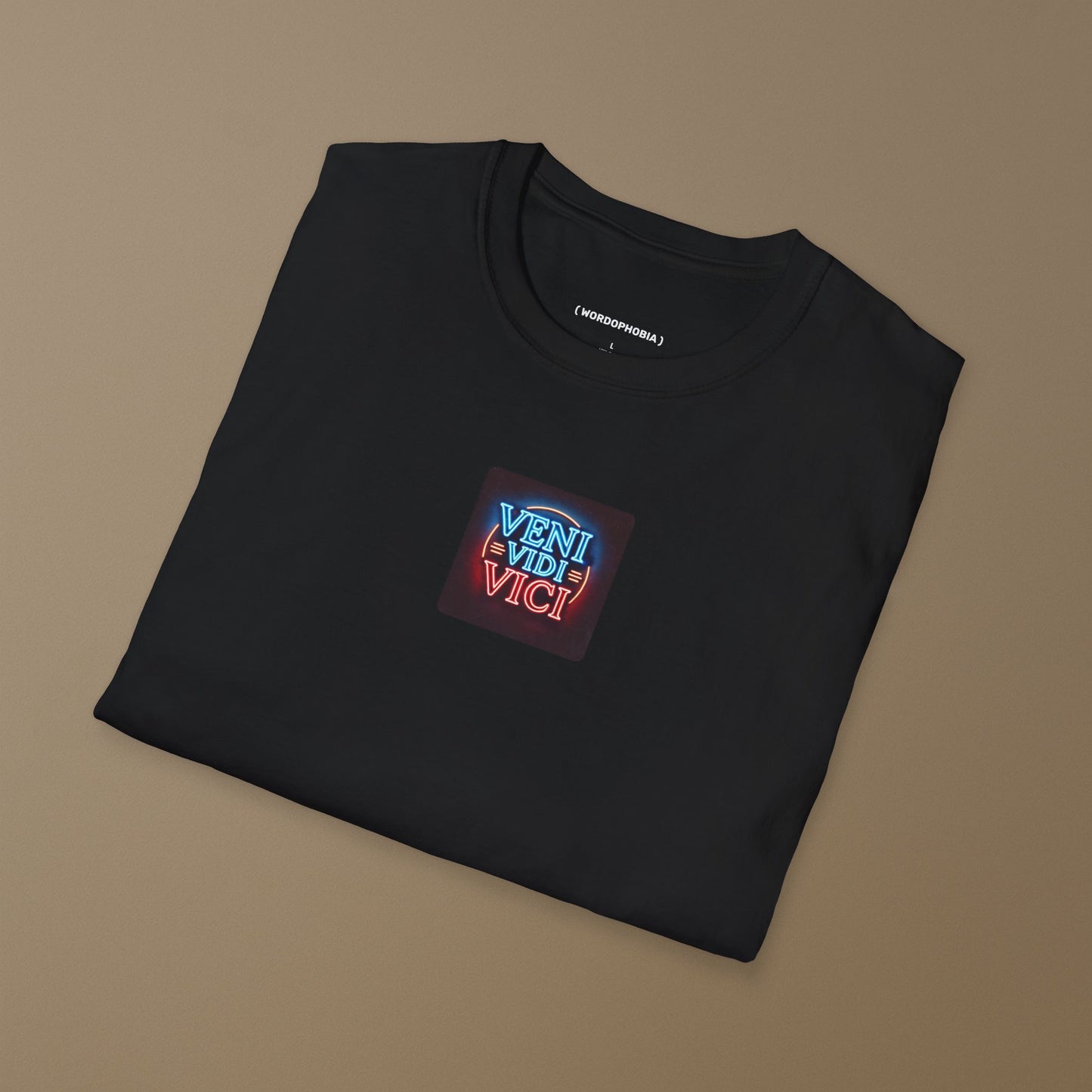 Folded black t-shirt with a colorful patch with the Latin phrase "Veni, Vidi, Vici" on a dark background