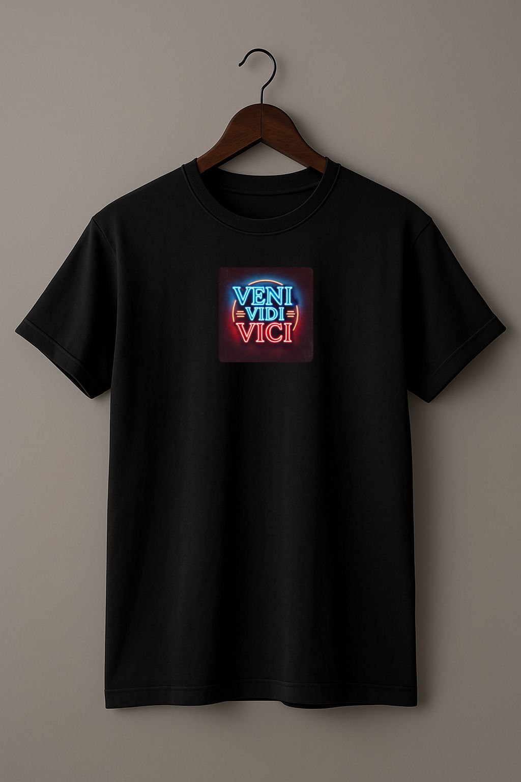 Black t-shirt with a colorful graphic with the Latin phrase "Veni, Vidi, Vici" on a hanger against a beige background 