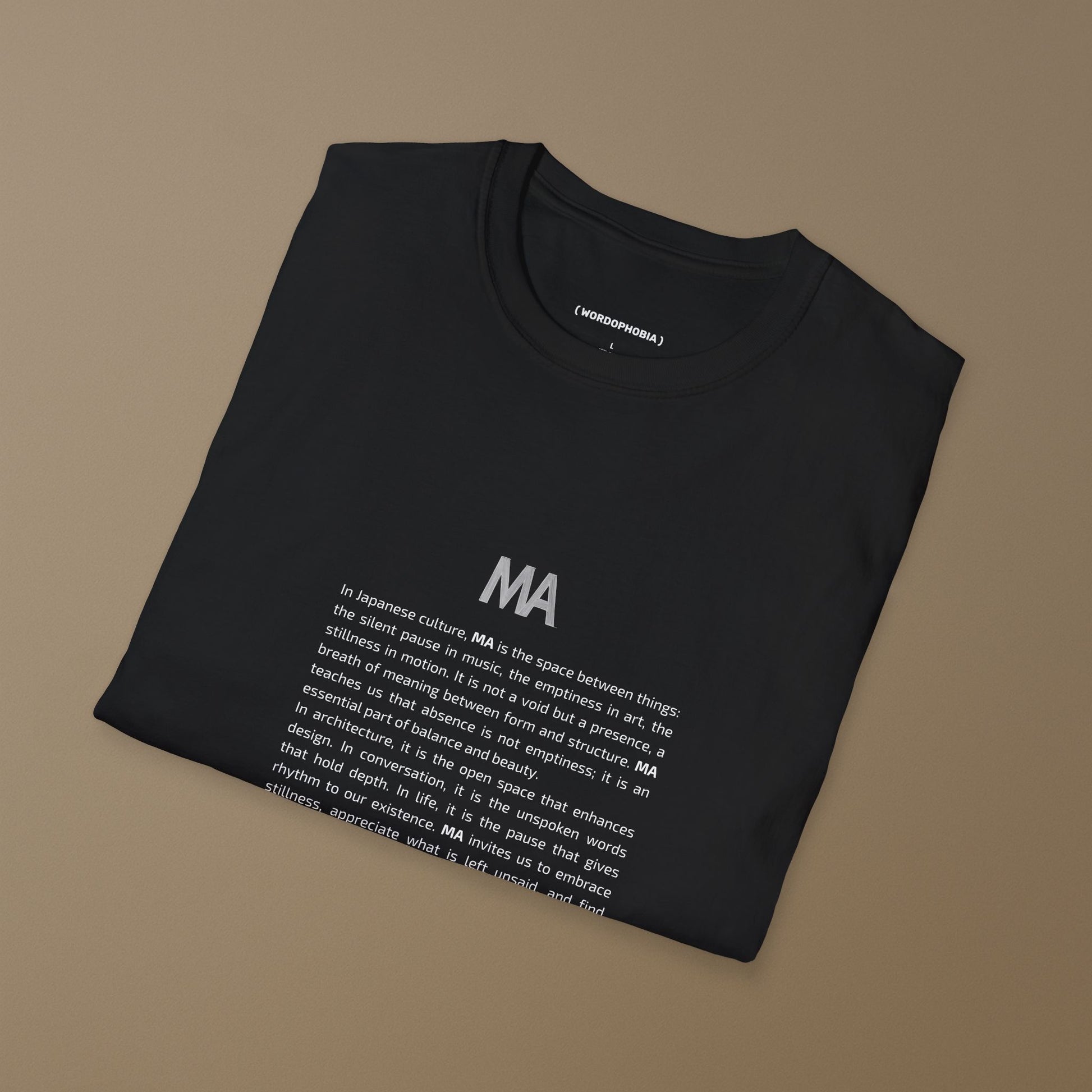 Folded black t-shirt with white text Ma and its concept on a beige background