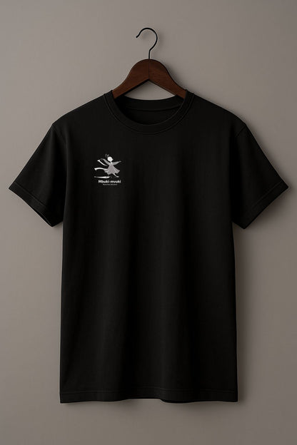 Black t-shirt with the African word Mbuki-mvuki and a tiny fantasy dancing mascot graphic on a hanger against a beige background